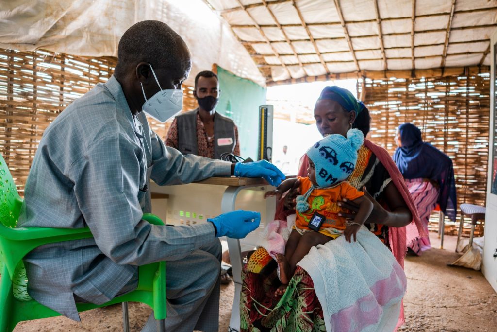 Community health worker in Uganda caring for a mother and child